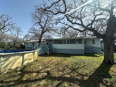 Rear view of property with an outdoor pool, a yar