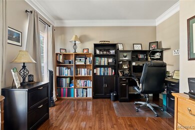 Wood floored home office featuring ornamental mold
