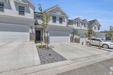 Traditional-style home featuring driveway, stone siding, an attached garage, and a residential view