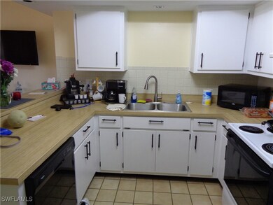 Kitchen featuring white cabinetry, black appliance