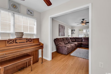 Living room featuring ornamental molding, light wo
