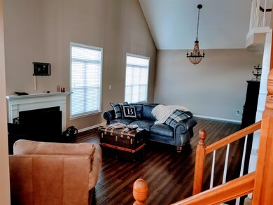 The living room features new hardwood flooring, vaulted ceilng  & fireplace.   