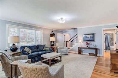 The Living Room has hardwood floors and plenty of light. The door to the right leads to the primary bedroom