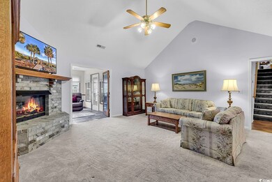 Carpeted living room with a ceiling fan, high vaul