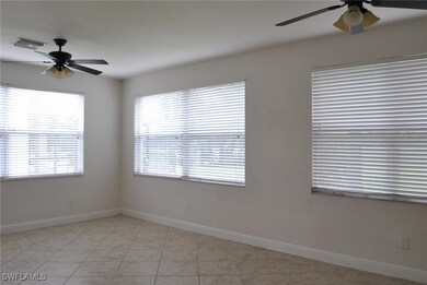 Empty room with a ceiling fan, baseboards, and light tile patterned floors