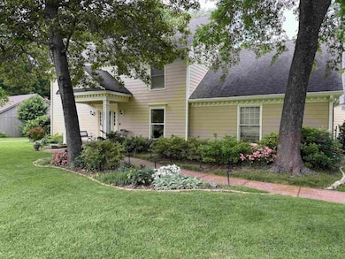 View of front of property featuring a shingled roof and a front lawn