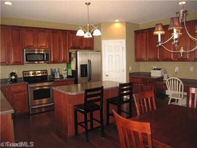 Kitchen. The kitchen is beautiful and open with solid surface counters and cherry cabinets! Kitchen island gives more food prepping space and extra seating! Built-in microwave, dishwasher, and oven/range included!