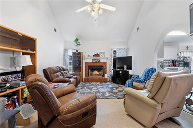 Living room featuring light carpet, a brick firepl
