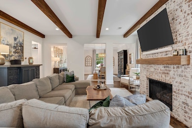 Living room with wood finished floors, beamed ceiling, a fireplace, recessed lighting, and baseboards