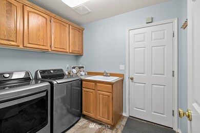 Large Utility room with tiled floors, a sink and washer and dryer are included.