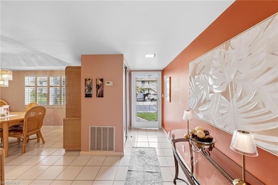 Foyer with light tile patterned floors and baseboards