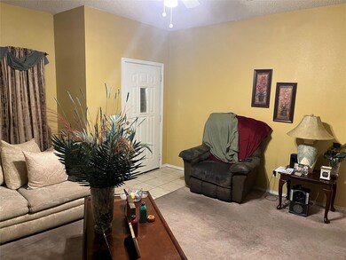 Carpeted living room with a textured ceiling and c