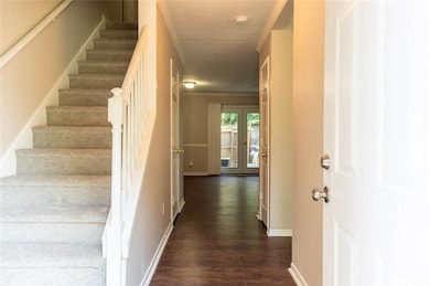 Stairway with wood finished floors, baseboards, and french doors