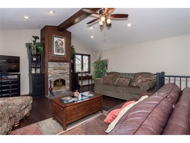 vaulted ceiling living room with wood burner that heats entire upstairs
