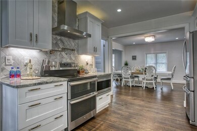 Kitchen featuring backsplash, appliances with stai