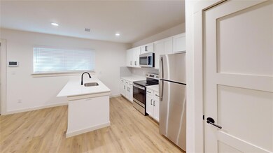 Kitchen with light wood-type flooring, a sink, vis