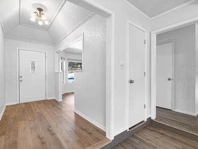 Large Foyer entrance featuring a chandelier, hardwood / wood-style flooring and decorative, vaulted ceiling.