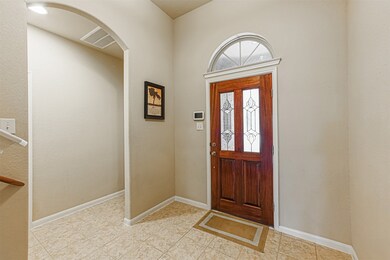 Tiled entry with leaded glass front door and high