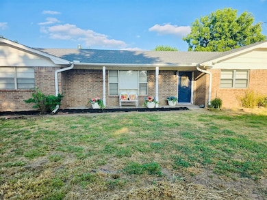 View of front facade with a front lawn, brick siding, and a shingled roof