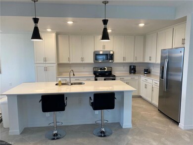Kitchen with light countertops, a sink, white cabi