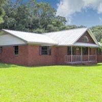 Back of house with a yard