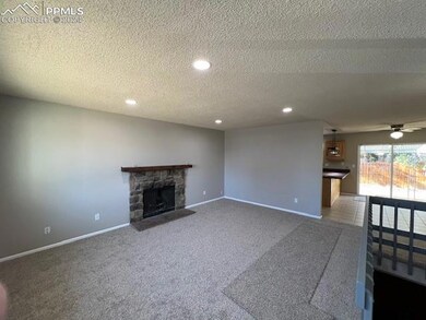 Unfurnished living room with ceiling fan, a stone 