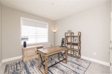 Second bedroom used as an office with carpet.