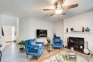 Living room with a ceiling fan, wood finished floo