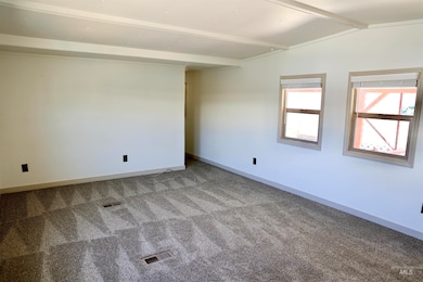 Carpeted spare room featuring baseboards
