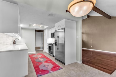 Kitchen with stainless steel appliances, white ca
