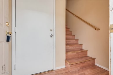 Stairs featuring wood finished floors and baseboards