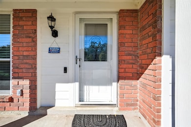 The elegant front entrance features a decorative glass door with a unique star design, a stylish outdoor lantern, and a welcoming 