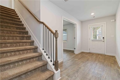 Foyer with light wood-type flooring, stairs, and recessed lighting