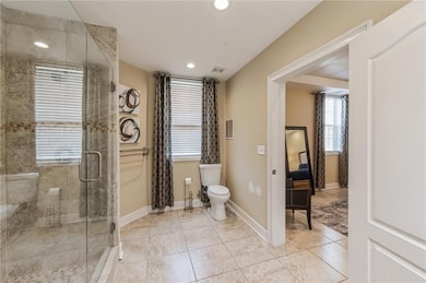 Full bath featuring toilet, a stall shower, recess