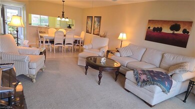 Carpeted living area with a chandelier