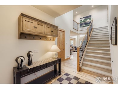 Welcoming entryway with warm wood accents and a view into the sunlit living room beyond.