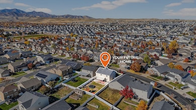 Aerial view of property's location with nearby suburban area and a mountainous background