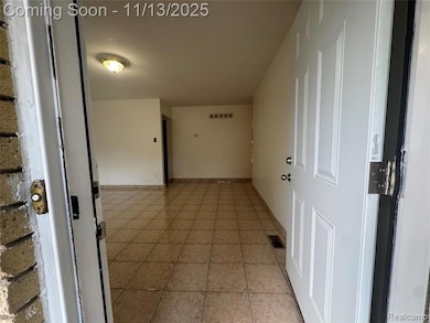 Corridor with light tile patterned floors and baseboards