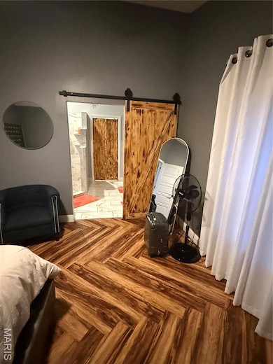 Bedroom with a barn door and connected bathroom
