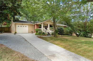 Ranch-style home featuring driveway, an attached garage, and covered porch