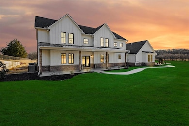 Back house at dusk featuring french doors and a ya