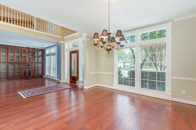 Natural light flows into the space from the leaded glass door with sidelights, to the large picture windows and transoms adorned with custom wood trim.