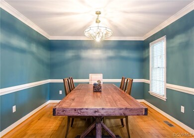 The dining room has hardwood flooring, arched entr
