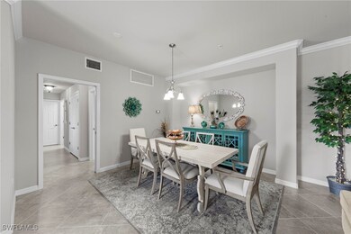 Dining room featuring a chandelier, light tile patterned flooring, and crown molding