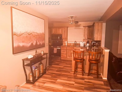 Kitchen with a breakfast bar area, stove, stainless steel microwave, a peninsula, and dark wood-style flooring