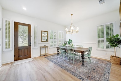 Dining space with wood finished floors and a chan