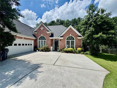 View of front of home with brick siding, concrete driveway, an attached garage, and a shingled roof
