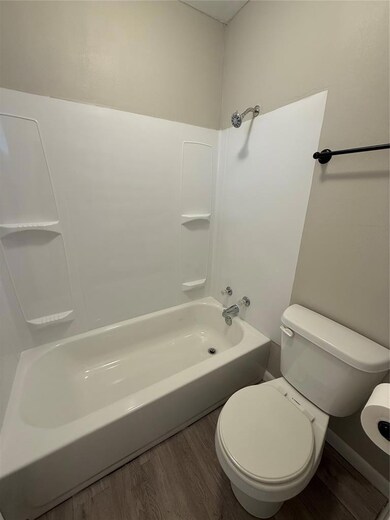 Full bath with wood finished floors and bathtub / shower combination