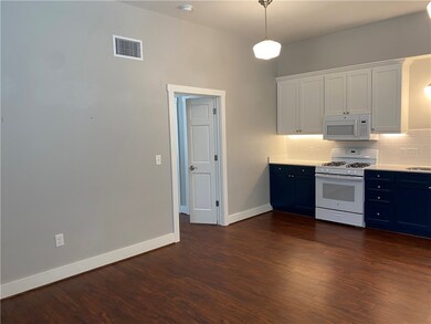 Kitchen featuring white appliances, blue cabinetry