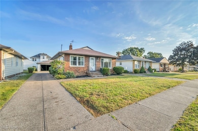 View of front of house with an outdoor structure, brick siding, a front lawn, and a chimney